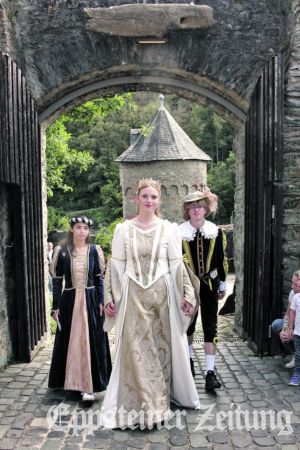 Burgfr&auml;ulein Luise I. flanierte mit ihrem Gefolge, Hofdame Maribel und Junker Daniel, &uuml;ber das Burgfest und wurde von vielen Besuchern auf Autogrammkarten angesprochen. Foto: Julia Palmert