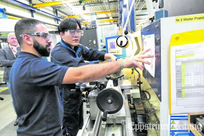 Ausbildungsleiter Vasilios Parasidis (li.) erklärt die Arbeit an der Drehbank. Foto: bpa